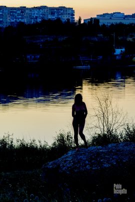 Silhouette of a naked girl on the lake at sunset. Nude photo by Pablo Incognito