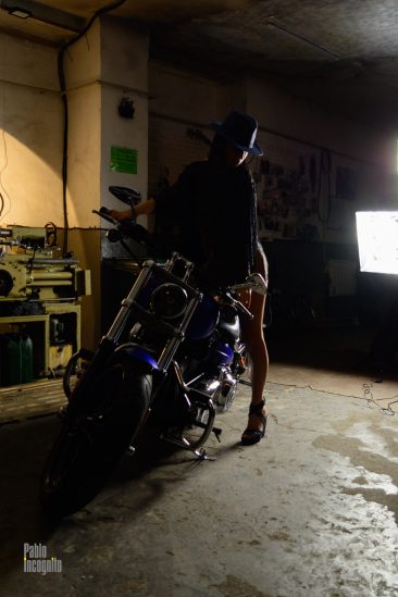 Girl with bare legs in a garage with a motorcycle