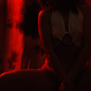 Girl posing in the studio in the red light of a lantern. Nude photo by Pablo Incognito