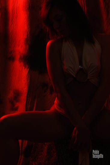 Girl posing in the studio in the red light of a lantern. Nude photo by Pablo Incognito