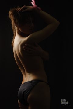 Girl posing nude, naked back on a black background. Nude photo by Pablo Incognito