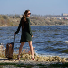 A girl with a suitcase on the river bank is going to pose for a nude photographer Pablo Incognito