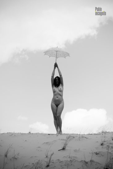 Naked in the desert under an umbrella black and white