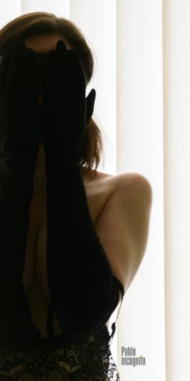 Portrait of a girl without a bra, covering her face with her hands