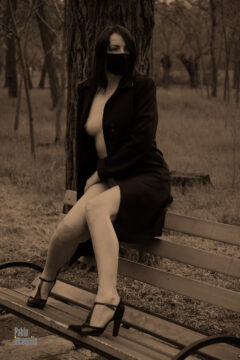 Topless girl sitting on a park bench