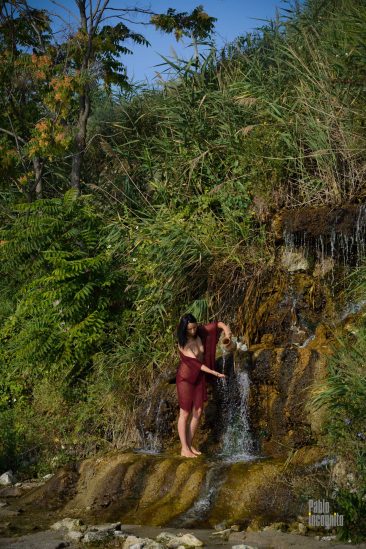 Half-naked woman with a jug at the waterfall