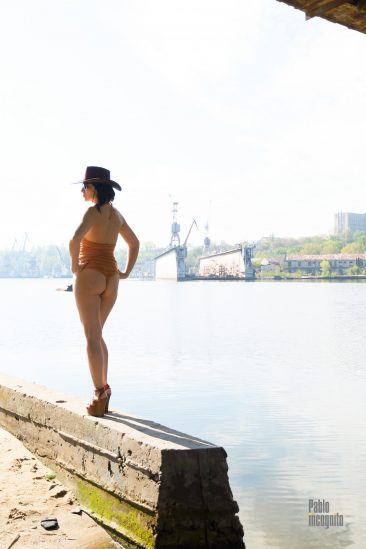Long-legged girl in a hat by the river, photo