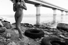 Nude with a cup on the background of the bridge