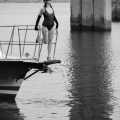 Black and white nude. A girl in a transparent bodysuit on the bow of the yacht. Photo by Pablo Incognito