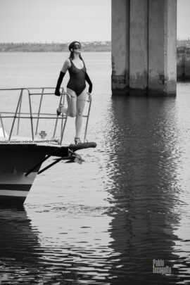 Black and white nude. A girl in a transparent bodysuit on the bow of the yacht. Photo by Pablo Incognito