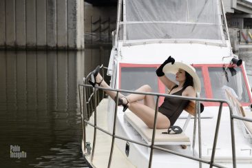 Lady in a chic hat is resting on a yacht