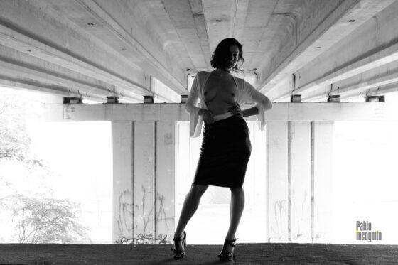 Girl posing topless under the bridge, black and white