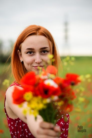 Red-haired girl with a bouquet of wild flowers