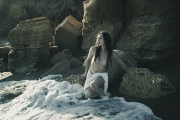 Girl with bare breasts in sea foam, photo