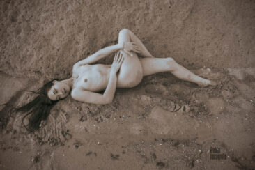 Nude photo session on the sea beach in wet sand