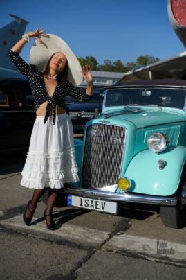 Lady in hat and vintage outfit near retro car photo