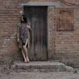 Woman in a raincoat near the old door photo by Pablo Incognito