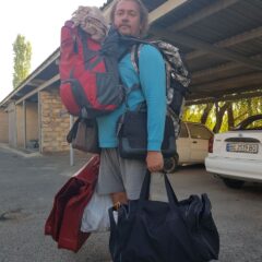Nude photographer Pablo Incognito with a backpack and bags gathered for a photo session