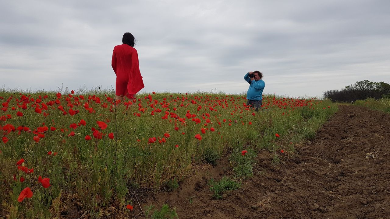 Nude photographer Pablo Incognito at a photo shoot in a field with poppies