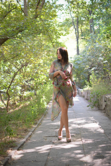 Girl in a translucent dress walks in the park glamor photo