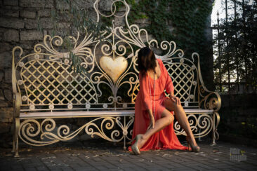Girl on a park bench in a nude evening dress