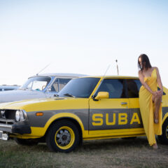 A girl in a long yellow dress poses near a yellow car. Nude photo session by Pablo Incognito
