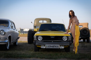 Nude girl near a beautiful car at an exhibition