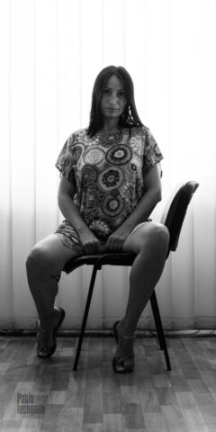 Woman erotically sits on an office chair black and white photo