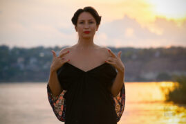 Model posing in off-the-shoulder dress at sunset glamor nude