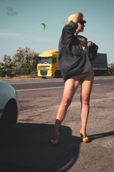 Girl in a men's shirt without panties on the track with a nude truck