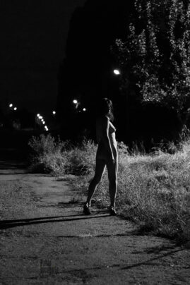 Lantern light illuminates her naked body, nude at night