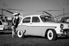 An elegant lady in front of a retro car. Photo session in the genre of glamor at the exhibition. Pablo Incognito