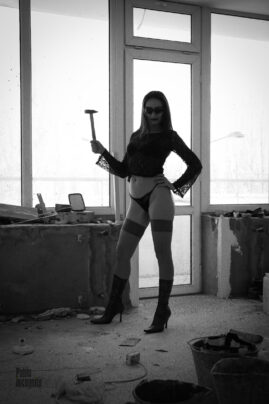 Girl in shorts and a hammer posing at a construction worker. Nude photo by Pablo Incognito