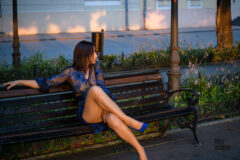 Woman sits on a bench in a pose Basic instinct, nude