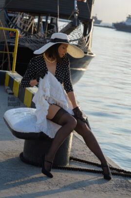 Pretty woman in hat and stockings at the port, nude
