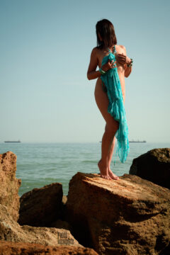 Nude girl with a turquoise cape on the stone. Nude photographer Pablo Incognito
