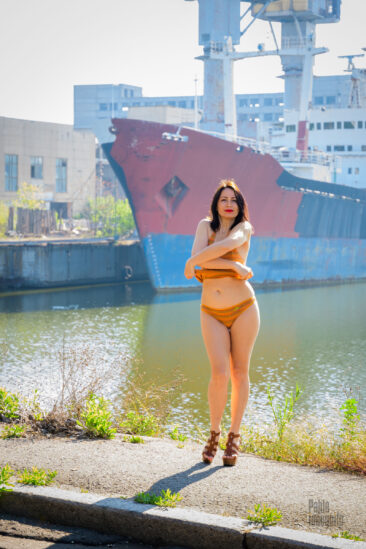 The girl took off her top on the background of the ship, nude