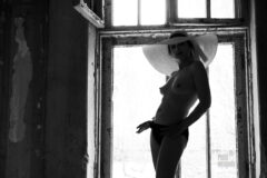 Topless. Model in shorts and a hat in the window opening. Nude photo by Pablo Incognito