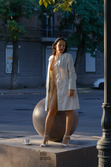 Iren Adler in a raincoat on a naked body poses near a granite ball. Nude photo by Pablo Incognito