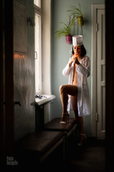 Dr. Iren lit a cigarette by the window in the hallway. Nude photo by Pablo Incognito