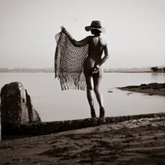 Nude in a net and a hat on the bank of the river. Nude photo by Pablo Incognito