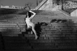 The girl sits on the steps of the Potemkin stairs nude