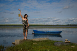 A girl with a catcher of sounds in her hand and a boat, on the banks of the river. Nude photo by Pablo Inсognito