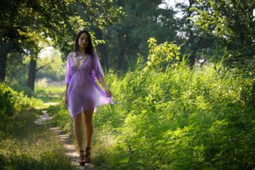 A girl in a transparent dress walks in the park