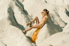 Naked girl sitting on the rocks